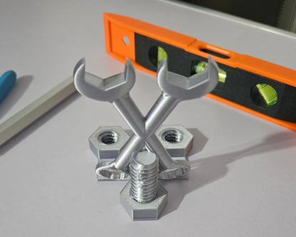 Metal wrenches and nuts on a gray surface with an orange level in the background